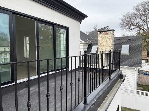 Classic wrought iron railing with ornamental balusters installed on a modern balcony.