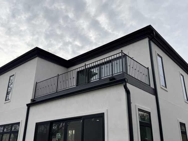Elegant black metal balcony railing with decorative knuckle balusters and rounded finial posts.