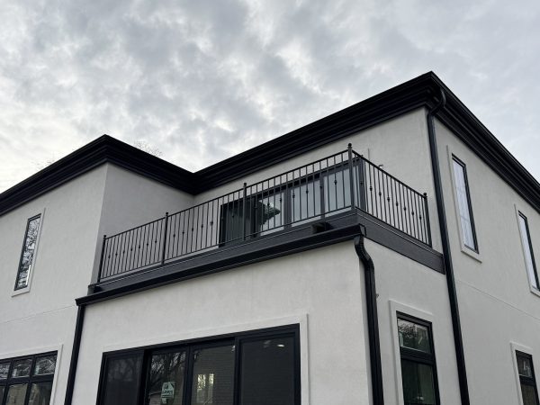 Elegant black metal balcony railing with decorative knuckle balusters and rounded finial posts.