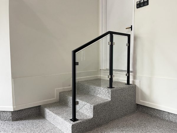 Framed glass railing for concrete stairs