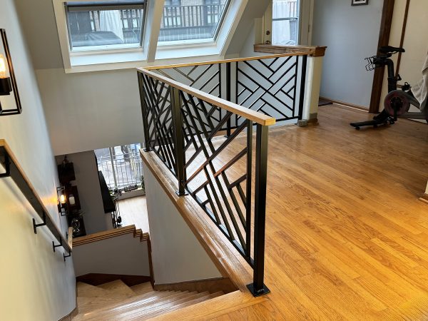 Custom wrought iron railing with chippendale design and red oak top