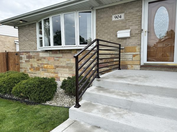 Exterior horizontal porch railing painted dark brown
