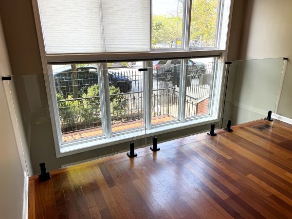 Frameless glass railing with black floor brackets