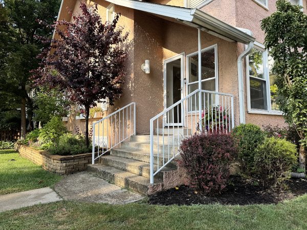 White railings with vertical pickets and roof support post