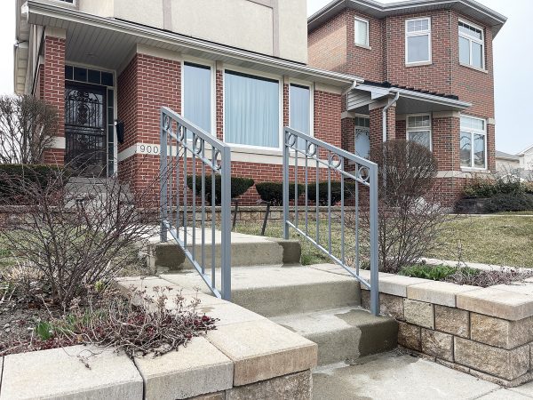 Classic metal stair railing with evenly spaced balusters and a row of circular details