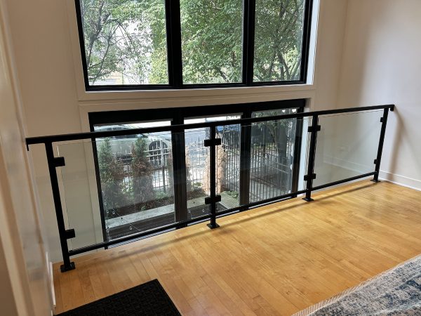 Interior framed glass railing with black brackets