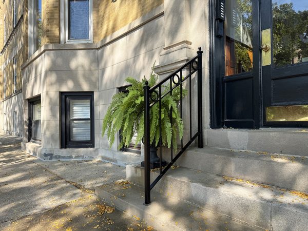 Black metal stair railing with decorative circular accents and vertical balusters.