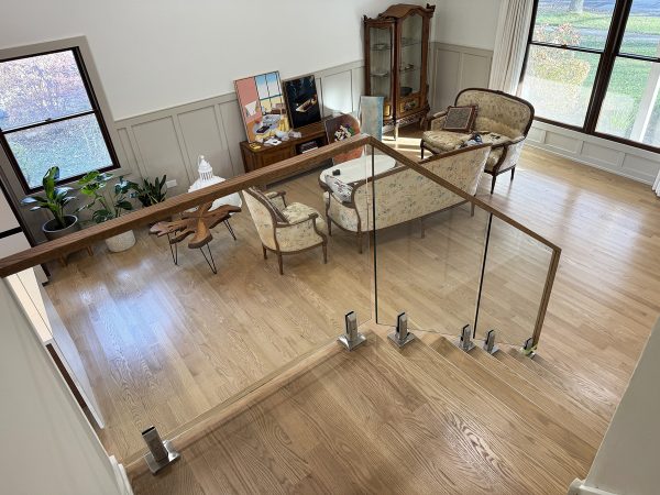 Glass railing with floor brackets and wooden frame