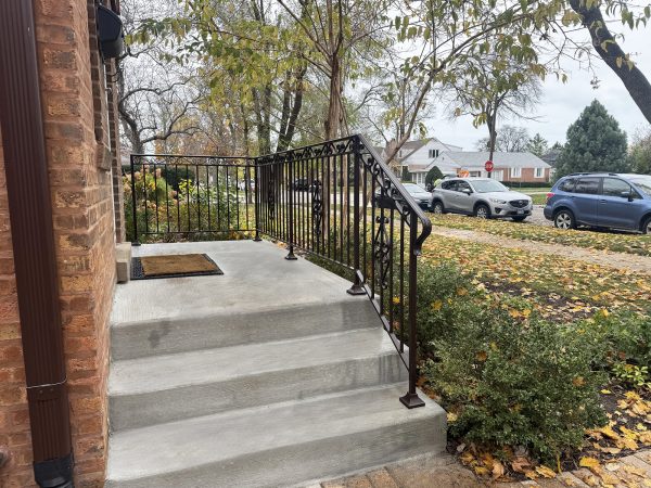 Decorative wrought iron stair railing with scrollwork and intricate baluster details.