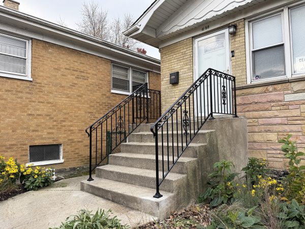 Classic black metal railing with ornamental accents and curved handrail ends.